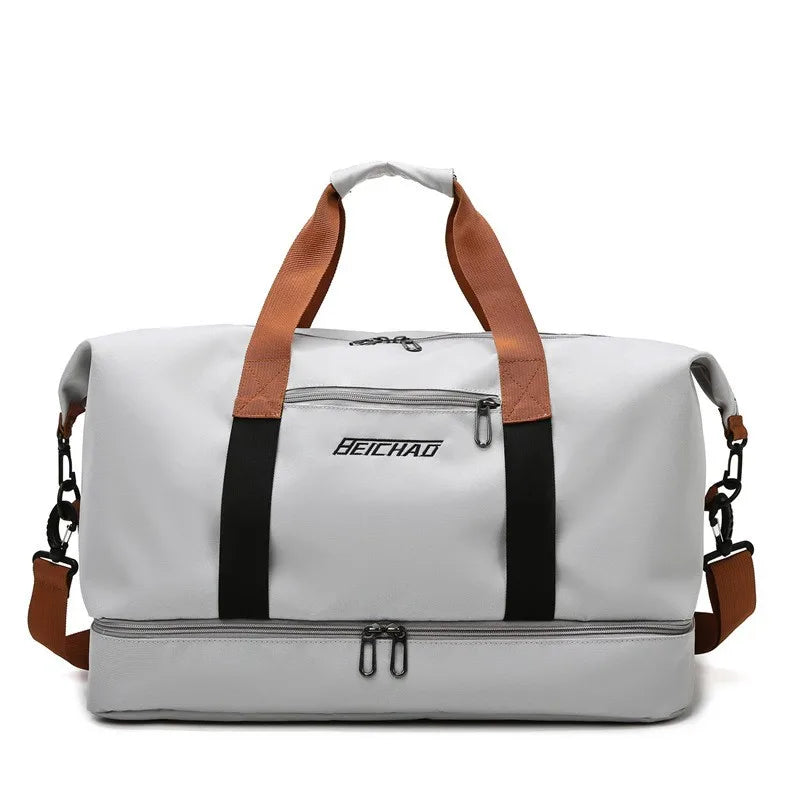 Gray duffel bag with brown straps and black accents on a white background