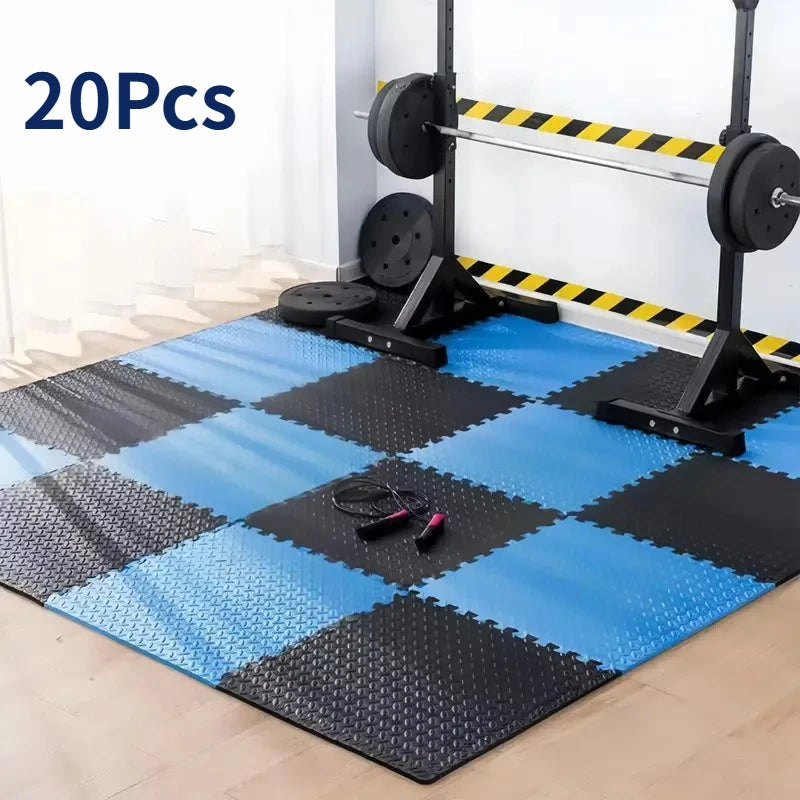Blue and black interlocking foam mats in a gym setting with weightlifting equipment.