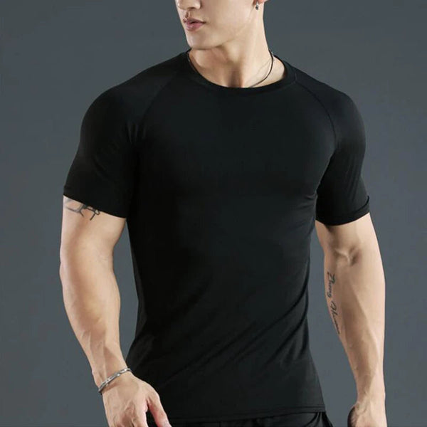 Man wearing a black athletic shirt against a gray background