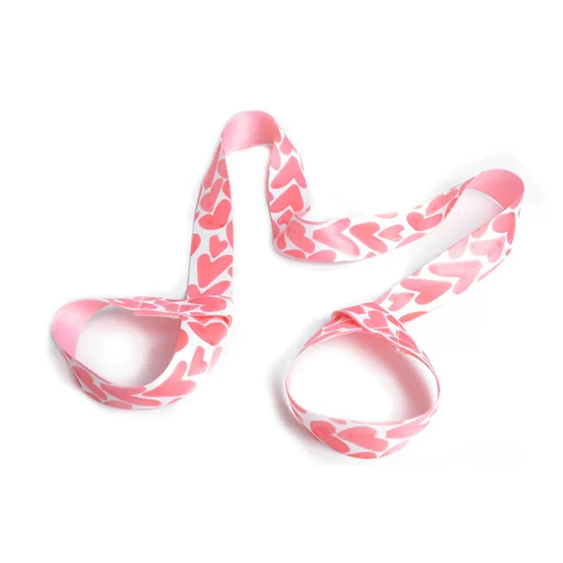 Pink heart-patterned adjustable yoga mat strap with looped ends for secure mat transport. Stylish and functional for yoga lovers and fitness fans.