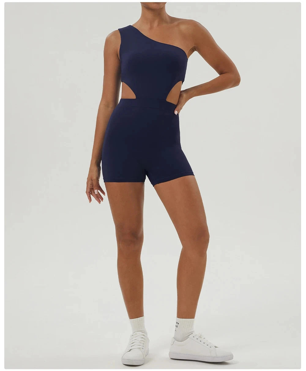Full-body view of navy blue Women One-Shoulder Sport Bodyduit Jumpsuit paired with sneakers, designed for active fitness routines.